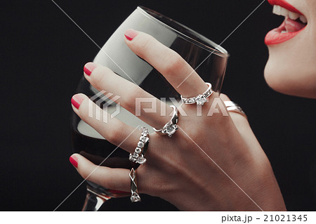 Woman Tasting wine hands all in rings close -up Woman Tasting wine hands all in rings close -up 21021345