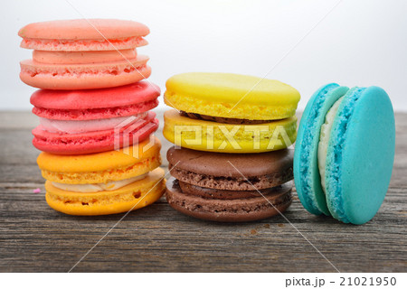close up of colorful macarons on wooden texture 21021950