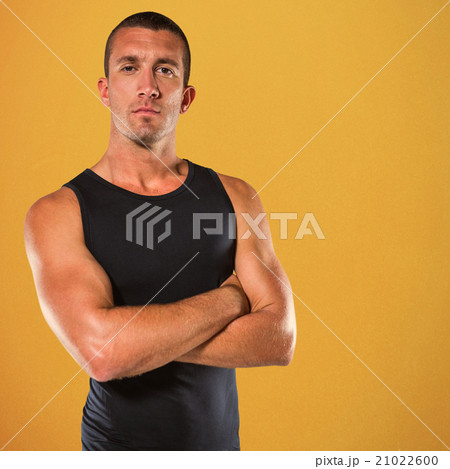 Composite image of confident athlete with arms crossed 21022600