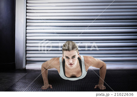 Composite image of muscular woman doing push-ups Composite image of muscular woman doing push-ups 21022636