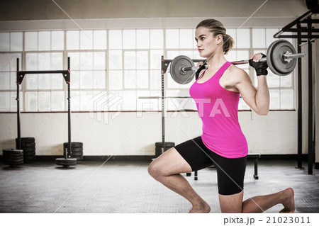 Composite image of sporty female bodybuilder lifting barebell Composite image of sporty female bodybuilder lifting barebell 21023011
