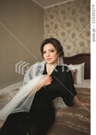 Luxury bride in black robe posing while preparing 21030274