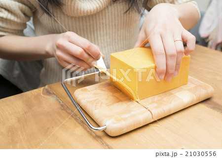 チーズを切る女性 21030556