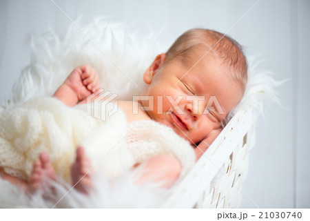 Cute newborn baby sleeps in basket Cute newborn baby sleeps in basket 21030740