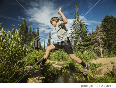 Boy (12-13) jumping in forest Boy (12-13) jumping in forest 21033641