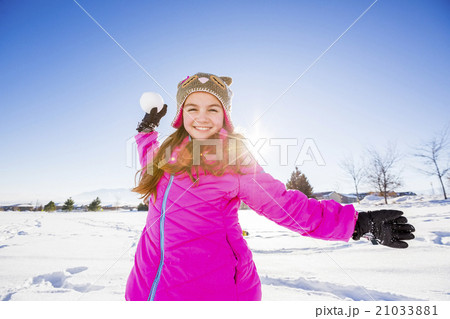 Girl (10-11) in pink jacket throwing snowball Girl (10-11) in pink jacket throwing snowball 21033881