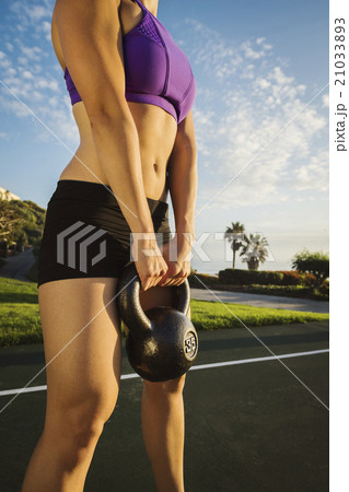 Young woman exercising with kettlebell 21033893