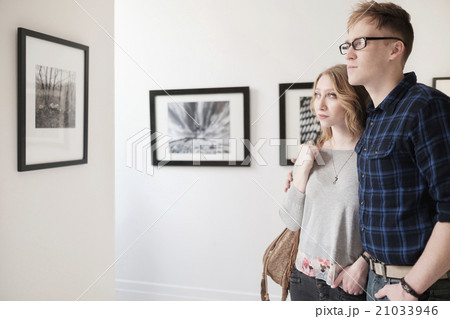 Young couple looking at photographs at museum Young couple looking at photographs at museum 21033946
