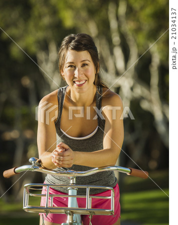 Young woman with bicycle in park Young woman with bicycle in park 21034137