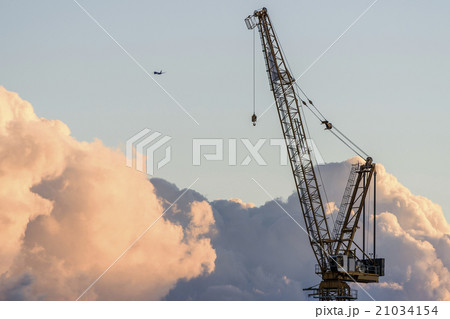 Crane with airplane in background at sunset 21034154