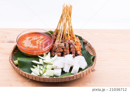 Barbecue satay served on traditional rattan plate 21036712