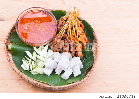 Barbecue satay served on traditional rattan plate 21036713