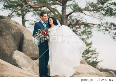Gorgeous bride, groom kissing and hugging near the 21043103