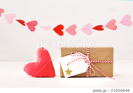 A garland of hearts above a small gift-wrapped box A garland of hearts above a small gift-wrapped box 21050646