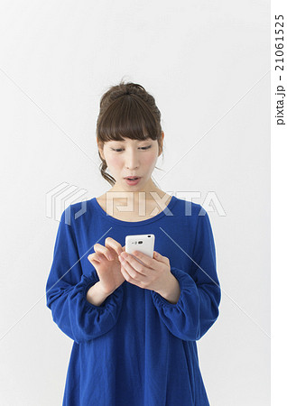 スマホを見て驚く若い女性 スマホを見て驚く若い女性 21061525