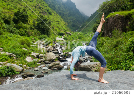 Woman doing yoga asana at waterfall 21066605