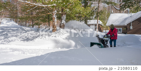 A man operates a snow thrower.  Canadian winter. 21080110