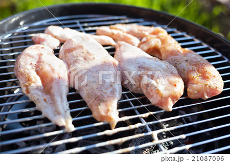 Raw chicken fillet breast cooking on barbeque grid Raw chicken fillet breast cooking on barbeque grid 21087096