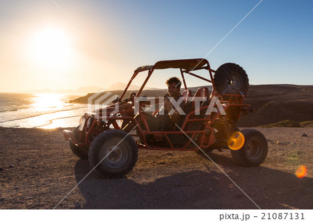 Man driving quadbike in sunset. 21087131