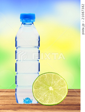 Blue bottle with water and fresh lime on table  21087382