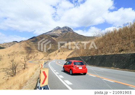 冬の湯布院のドライブイメージ 由布岳と赤いコンパクトカー の写真素材