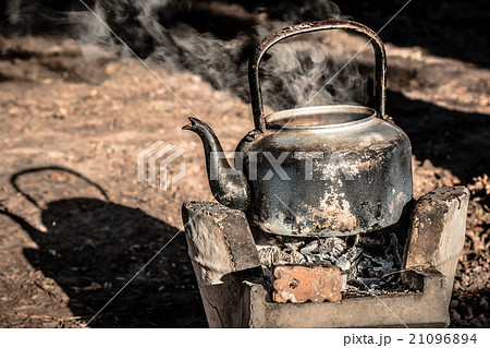 old aluminium kettle on stove, is boiling water. old aluminium kettle on stove, is boiling water. 21096894