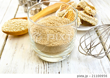 Flour sesame in glassful with spoon on board Flour sesame in glassful with spoon on board 21100956
