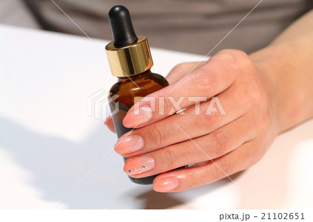 美容液を持つ女性の手 21102651