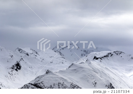 Snowy mountains in fog at gray morning 21107334