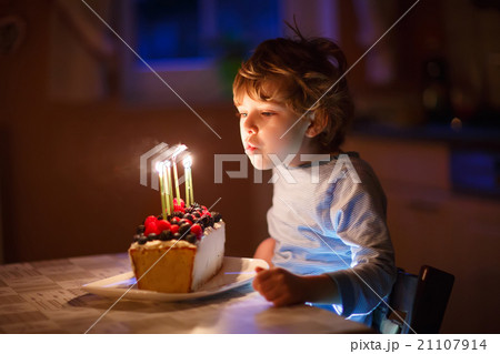 Little kid boy blowing candles on birthday cake 21107914