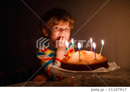 Little kid boy blowing candles on birthday cake 21107917