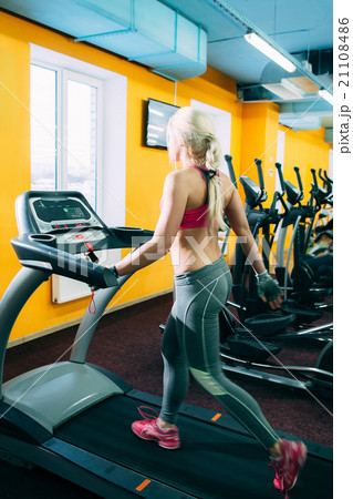 Athletic girl jogging on treadmil in gym Athletic girl jogging on treadmil in gym 21108486