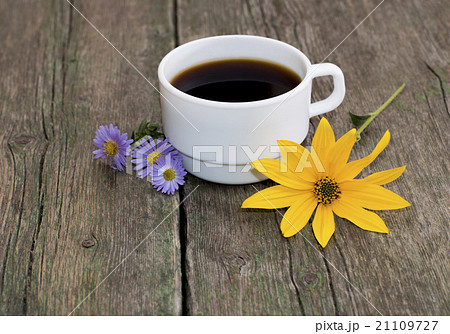 cup of coffee decorated with flowers on a table cup of coffee decorated with flowers on a table 21109727