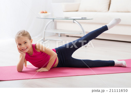 Girl doing exercises lying on the mat 21111650