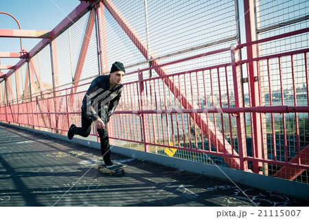Skateboarder cruise on bridge 21115007