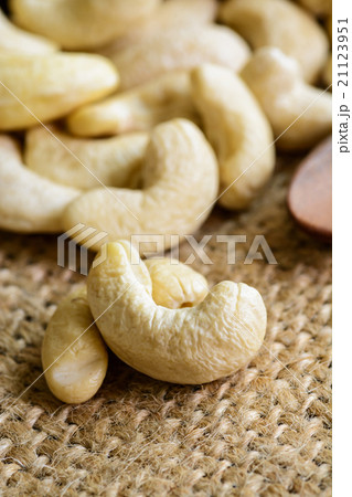 Raw cashew nuts with wooden spoon on sackcloth 21123951