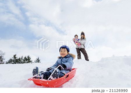 雪の公園でソリで遊ぶ親子 21126990