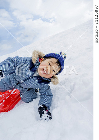 雪の公園でソリ遊びをする男の子 21126997
