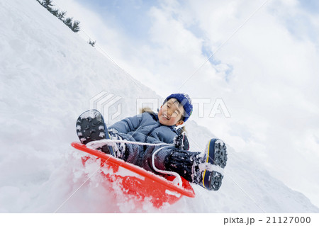 雪の公園でソリ遊びをする男の子 21127000