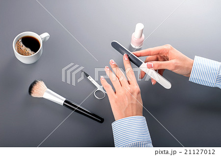 Female clerk using nail file. Female clerk using nail file. 21127012