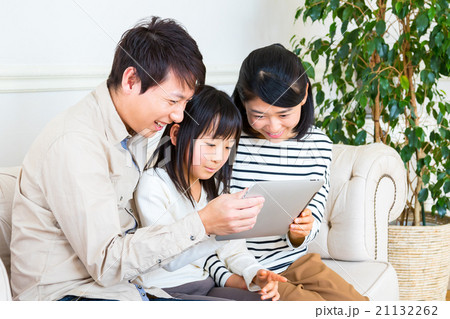 タブレット端末を使う3人家族　家族団らん　父親　母親　娘　コピースペース　仲のいい家族 21132262