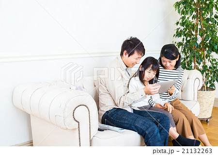 タブレット端末を使う3人家族　家族団らん　父親　母親　娘　コピースペース　仲のいい家族 21132263