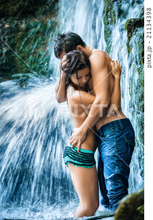Couple hugging and kissing under waterfall 21134398