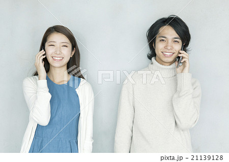 並んで電話する20代男女 並んで電話する20代男女 21139128
