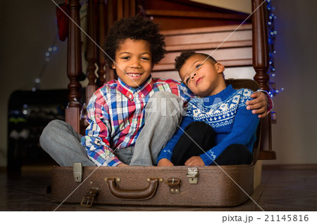 Smiling kids sit inside suitcase. 21145816