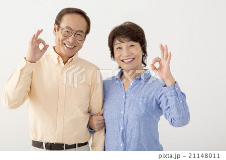腕を組みＯＫサインをするシニア夫婦 21148011