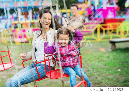 Mother and daughter at fun fair, chain swing ride 21149324