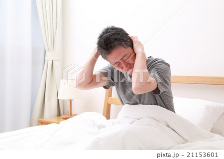 ベッドで頭を抱える中高年男性 21153601
