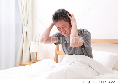 ベッドで頭を抱える中高年男性 21153602