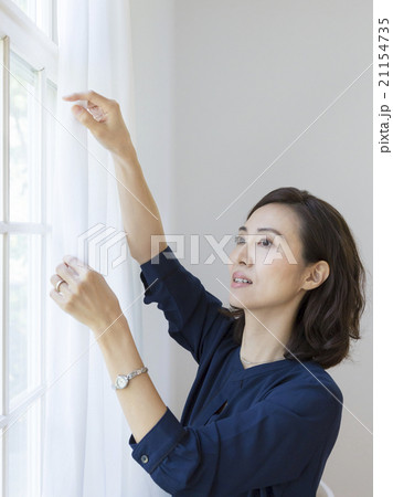 カーテンを持つ40代の女性 21154735